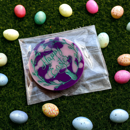 easter wax melt circle in clear packaging on grass background with easter eggs